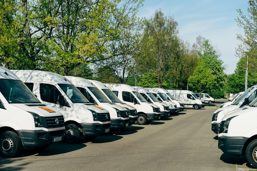Deretan mobil van putih operasional terparkir di area parkir