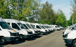 Deretan mobil van putih armada usaha yang terparkir di area parkir