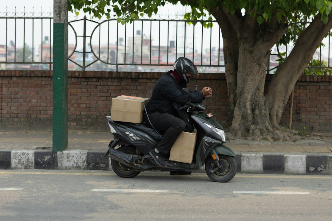 Kurir pengantar barang sedang menunggu sambil memeriksa ponselnya