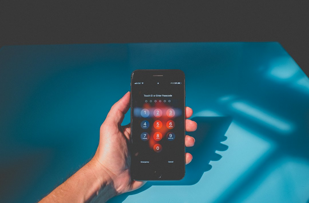 Seseorang memegang smartphone, menggambarkan pengguna yang mengelola akun aplikasi GPS pelacak